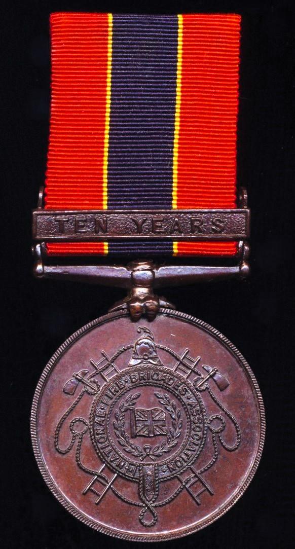 National Fire Brigades Association. Bronze 10 years long service medal, with integral top brooch bar 'Ten Years'. Officially numbered & named (11696 John C. Baines.)